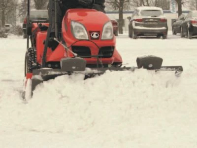 snow plough fitted to ride on mower clearing snow